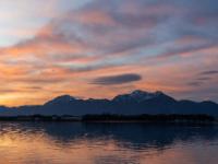 Orange leuchtende Morgenwolken über Hochries und Hochfelln